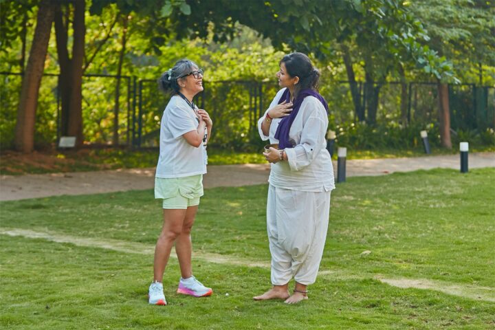Two participants facing each other on the lawn, hands resting on their chests
