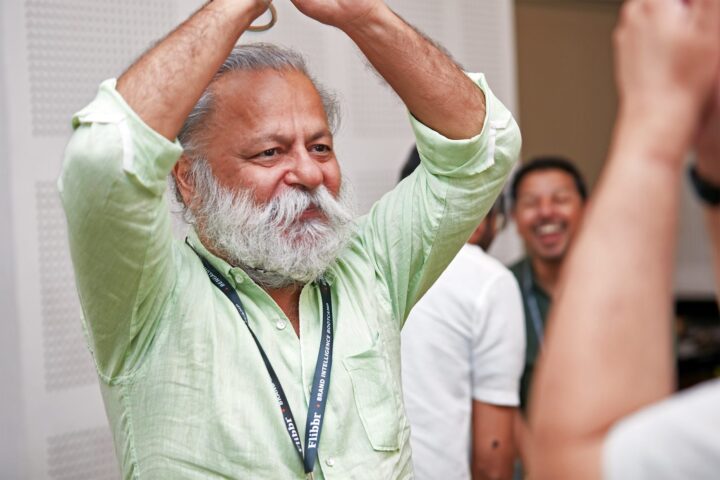 A participant with arms raised overhead, smiling