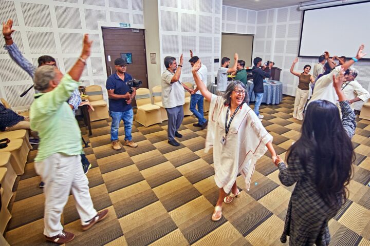 Participants moving together in the session room, arms raised