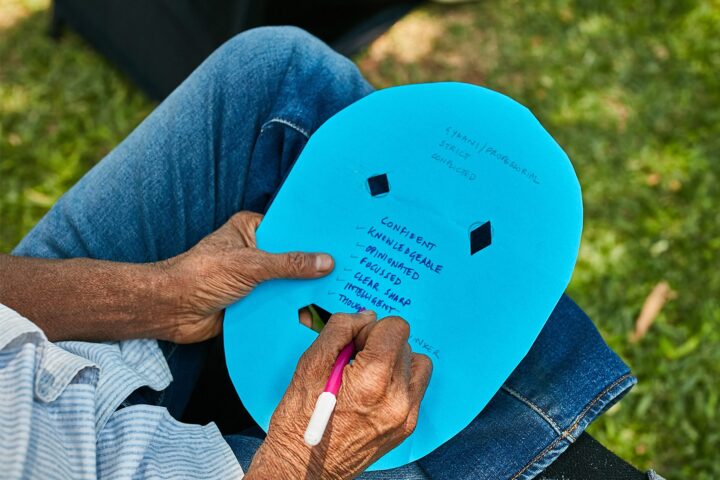 Close-up of hands writing on a blue exercise card