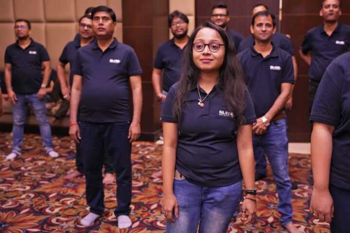 A participant standing among colleagues in branded polo shirts, smiling
