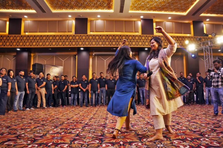 Two participants dancing in the open floor while the room watches