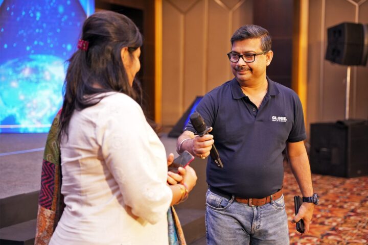 A participant speaking into a microphone held out to him