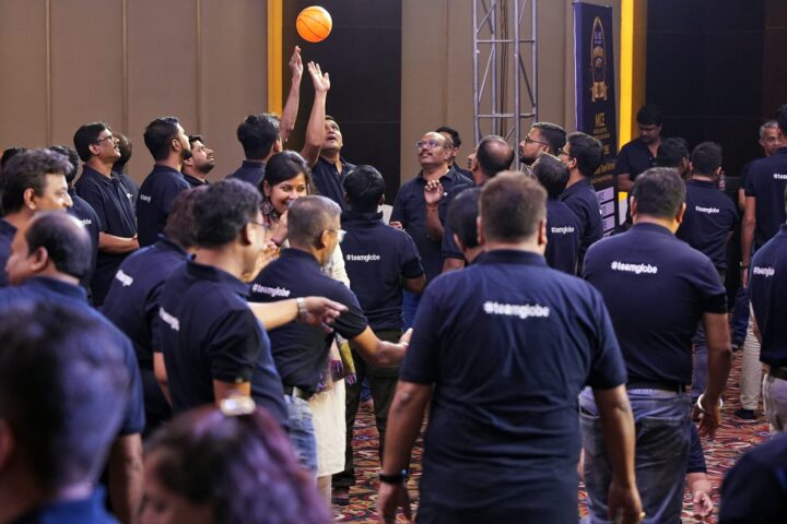 A ball in the air above the crowd as a participant reaches for it