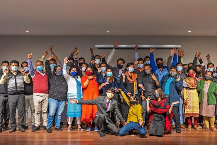 The whole group photographed together, arms raised