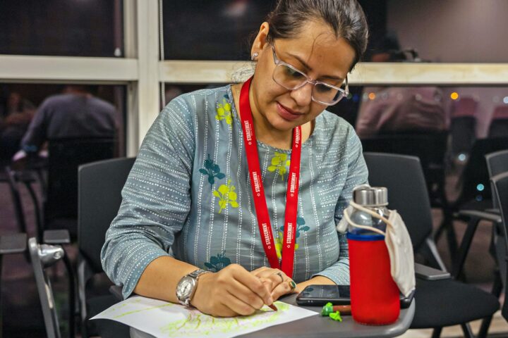 A participant drawing on a sheet of paper at a small table