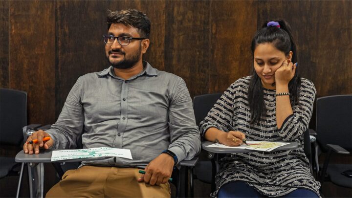 Two participants comparing their drawings while seated