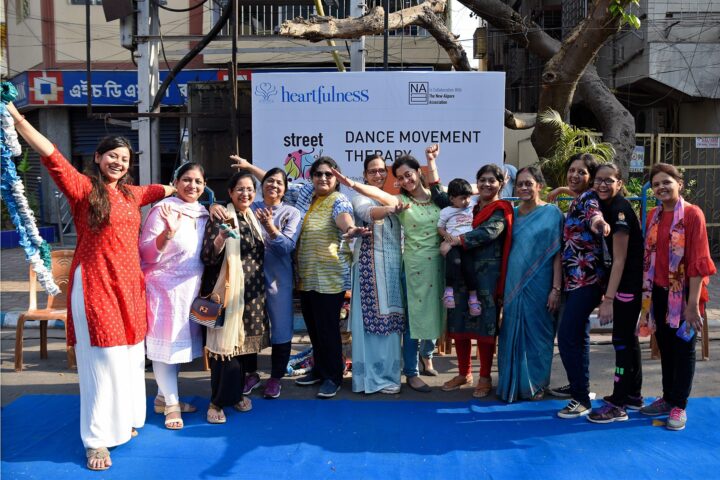 The group photographed together in front of a Heartfulness banner reading Dance Movement Therapy