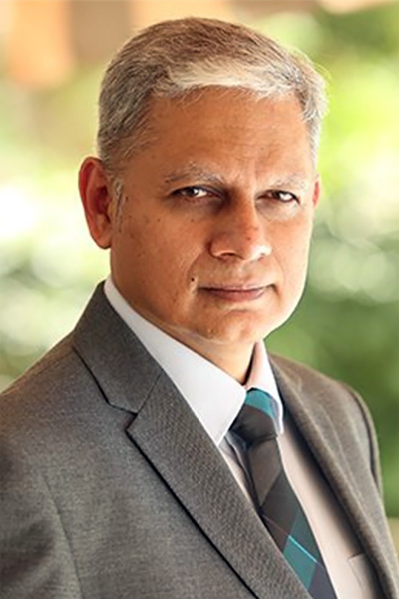 Col. Sudip Mukherjee, NLP trainer and advisory board member, photographed outdoors in a suit and tie.