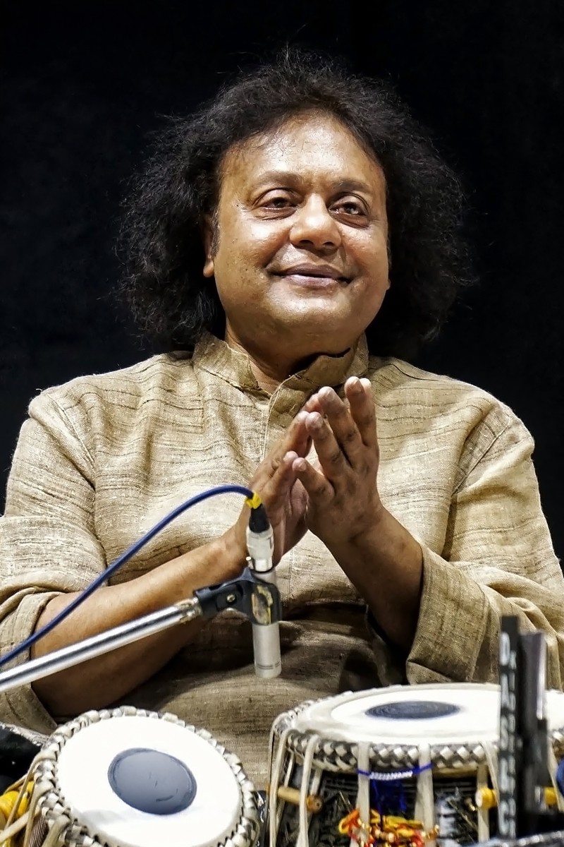 Pt. Tanmoy Bose, tabla player and advisory board member, seated at a pair of tabla mid-performance.
