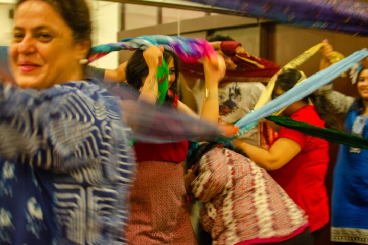 A participant smiling as lengths of cloth cross the frame in front of her