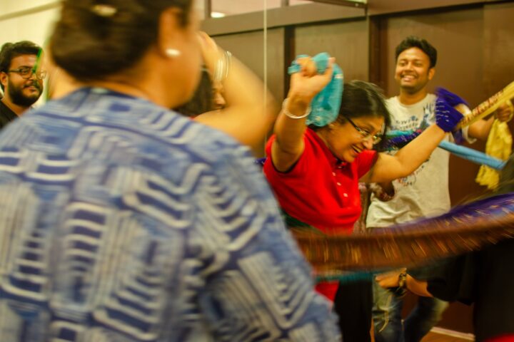 Participants passing a braided rope of cloth between them, laughing