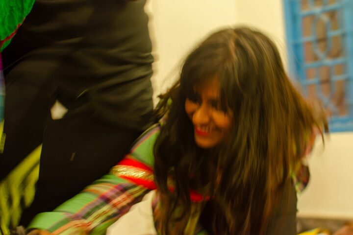 A participant mid-turn, her hair swinging, a strip of cloth trailing past