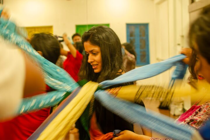 Pale blue and yellow cloth fanning out around a smiling participant